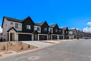 View of asphalt street featuring a residential view and curbs