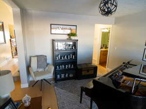 Sitting room with wood finished floors, a textured ceiling, and a chandelier