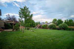Fenced backyard featuring a playground