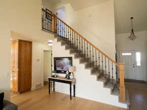 Stairway featuring hardwood / wood-style floors and a high ceiling