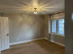 Spare room featuring a textured ceiling and light wood finished floors