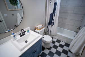 Full bathroom with tile patterned floors, vanity, and shower / bath combo with shower curtain
