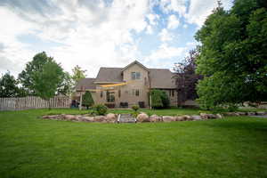 Back of house featuring a patio area and roof with shingles