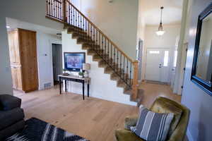 Entryway featuring a high ceiling, wood finished floors, and stairway