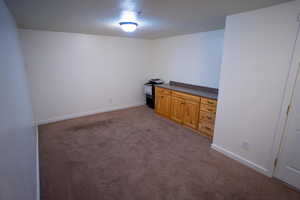 Carpeted spare room featuring baseboards