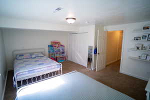 Carpeted bedroom with a closet and baseboards