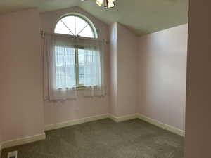 Carpeted empty room featuring baseboards and a ceiling fan