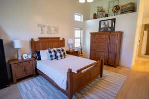 Bedroom featuring a high ceiling and light wood-style floors