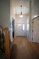 Entrance foyer featuring stairway, light wood-style flooring, and a towering ceiling