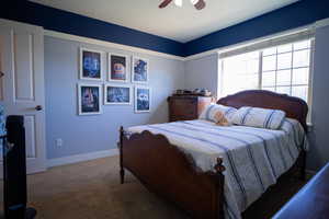 Carpeted bedroom featuring baseboards and a ceiling fan