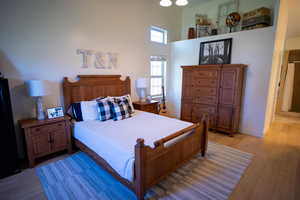 Bedroom with light wood-type flooring and a high ceiling