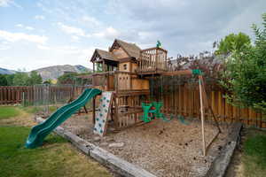 View of play area featuring a fenced backyard and a mountain view