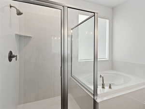 Full bathroom featuring a shower stall and a garden tub