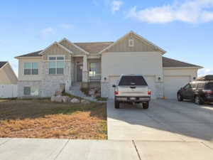 Craftsman inspired home with stone siding, driveway, a garage, and board and batten siding