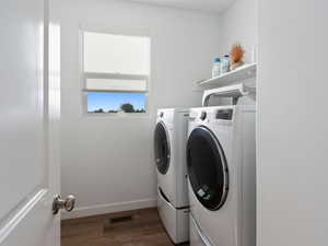 Laundry room featuring washing machine and dryer and wood finished floors