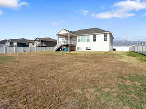Rear view of property featuring stairs, a fenced backyard, and a residential view