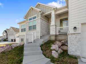 Property entrance with stone siding and board and batten siding