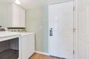 Washroom featuring washing machine and clothes dryer and cabinet space
