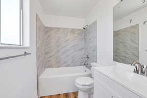 Full bathroom with vanity, tub / shower combination, and wood finished floors