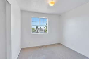 Carpeted empty room featuring baseboards