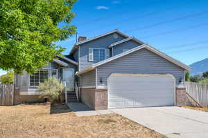 View of front facade with brick siding, driveway, an attached garage, and a mountain view