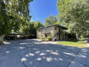 View of side of property with stairs and asphalt driveway