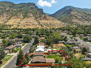 Aerial view of residential area featuring mountains and property boundaries highlighted