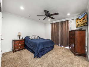 Bedroom with light colored carpet, ornamental molding, recessed lighting, and a ceiling fan