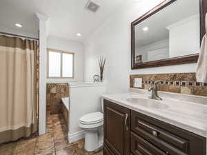 Full bath with ornamental molding, vanity, a shower with shower curtain, recessed lighting, and stone tile floors