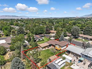 Aerial view of residential area featuring property parcel outlined and mountains