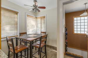 Dining room with a ceiling fan and light tile patterned floors