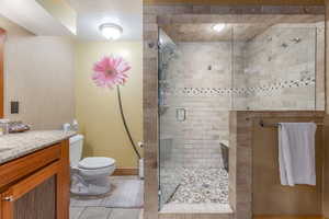 Full bathroom featuring a shower stall, tile patterned floors, and vanity