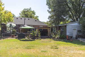Rear view of property featuring a yard, a deck, and a gazebo
