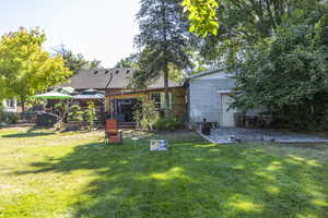 Back of property with a gazebo, a lawn, and concrete block siding