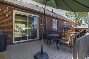 Wooden terrace with a grill and outdoor dining area