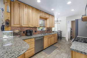 Kitchen with backsplash, recessed lighting, stainless steel dishwasher, freestanding refrigerator, and stove