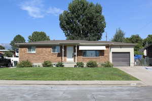 Ranch-style house featuring concrete driveway, an attached garage, and brick siding