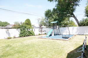 Fenced backyard with a playground