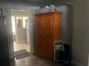 Corridor featuring light wood finished floors and arched walkways