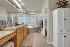 Bathroom with a shower stall, a garden tub, double vanity, tile patterned floors, and recessed lighting