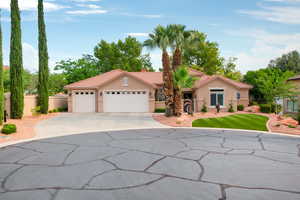 Mediterranean / spanish-style home featuring stucco siding, an attached garage, concrete driveway, a tile roof, and a chimney