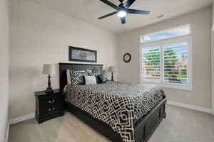 Bedroom featuring light carpet and a ceiling fan