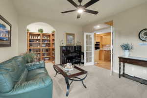 Living room with ceiling fan and light carpet