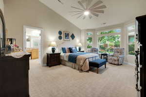 Bedroom with light colored carpet, high vaulted ceiling, ensuite bath, and ceiling fan