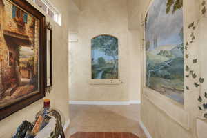 Hallway featuring baseboards and tile patterned floors