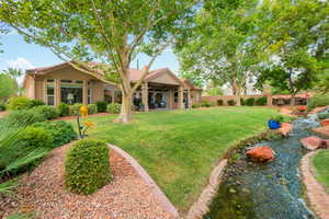 Fenced backyard with a ceiling fan, a patio, and a small pond
