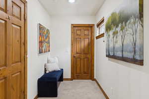 Entryway featuring light carpet and baseboards