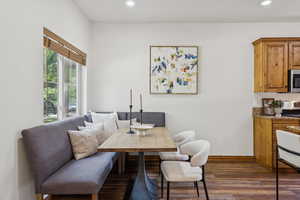Dining area with dark wood finished floors and recessed lighting