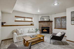 Living room featuring carpet floors, a fireplace, a textured ceiling, and recessed lighting