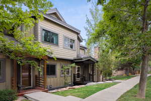 View of front of home with board and batten siding, a front lawn, and a chimney